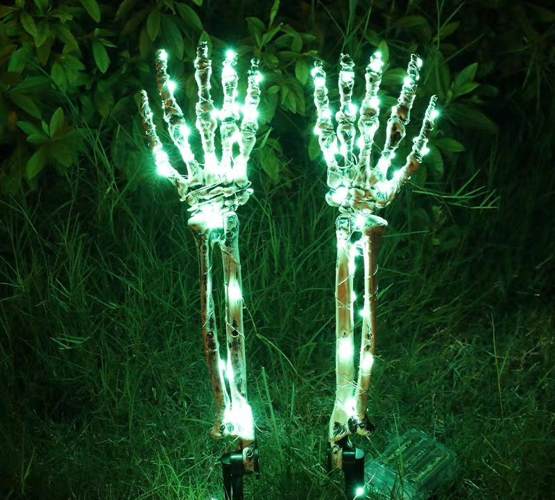 Solar-powered glowing skull arm garden stake light