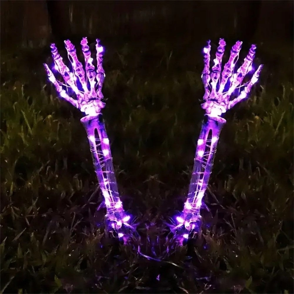 Solar-powered glowing skull arm garden stake light